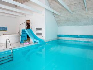Husbyにある12 person holiday home in Ulfborgの建物内のスイミングプール(青い滑り台付)