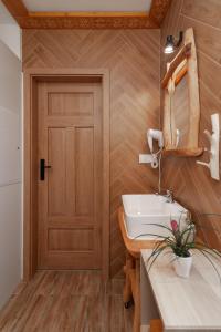 a bathroom with a sink and a wooden door at Kotelnica View in Groń