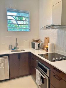 a kitchen with a sink and a microwave at Breathtaking 2-Bedroom Beachside Apartment in San Juan