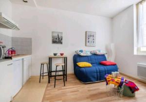 een kleine kamer met een blauw bed en een tafel bij Studio très calme 2 pers Centre in Limoges