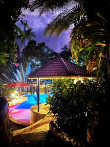 a pool with a gazebo next to a resort at The Scarlet Villas in Ojochal