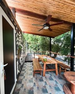 een patio met houten tafels en een plafondventilator bij Hotel Tortuga Village in La Herradura
