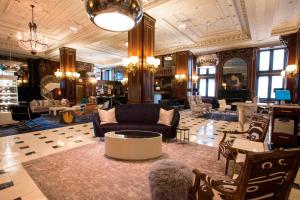 a large room with a lobby with couches and chairs at The Blackstone, Autograph Collection in Chicago