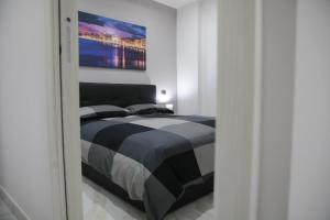 una camera da letto con un letto e un dipinto sul muro di Kellas home a Bari