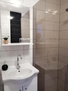 a white bathroom with a sink and a shower at Guest House Končar in Plitvička Jezera