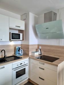 uma cozinha com um lavatório e um micro-ondas em Eau Bleue d'Eden em Saint-Hilaire-de-Riez