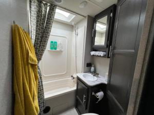 a bathroom with a sink and a tub and a shower at Lake front RV experience close to port Canaveral and Kennedy space center in Titusville