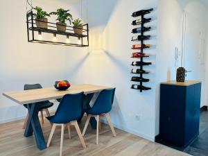 a dining room with a wooden table and blue chairs at MyBLEISURE Premium Apartment mit Küche und Netflix nahe Heidelberg I SAP, MLP, Unternehmen im Rhein-Neckar-Kreis in Rauenberg