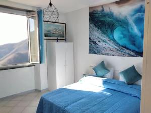 a bedroom with a blue bed and a painting on the wall at CasarinoLaurino Valle Del Golfo Healthy Air Above The Sea in Uscio