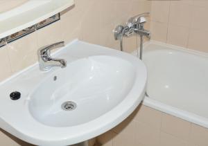 a white sink in a bathroom next to a tub at Residencial A Doca in Faro