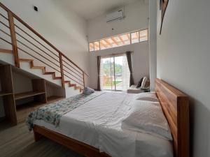 a bedroom with a large bed and a staircase at Ohana Beach Hotel in Playas