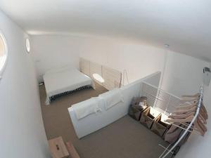 a white room with a bed and a bench at Casottino presso residenza Rosso di Sera in Capoliveri