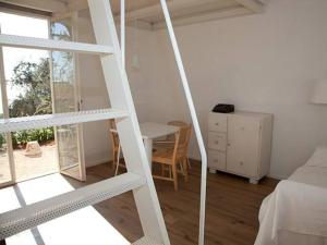 a room with a ladder and a desk and a bed at Casottino presso residenza Rosso di Sera in Capoliveri