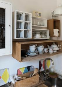 a kitchen with a sink and a cabinet with dishes at Casottino presso residenza Rosso di Sera in Capoliveri +5 photos