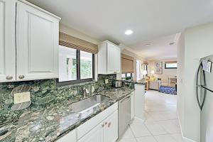 a kitchen with white cabinets and marble counter tops at Shell Shack #9 in Juno Beach