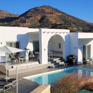 uma villa com piscina em frente a uma montanha em Galini Breeze em Agía Galíni