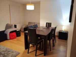 a dining room with a black table and chairs at Cantinho da Ana in Viana do Castelo