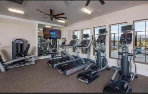 einen Fitnessraum mit Laufbändern und Crosstrainern in einem Zimmer in der Unterkunft Near Coachella and Stagecoach Palm Springs , PGA resort Villa ,Golf, community pool, gym in La Quinta