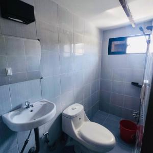 a bathroom with a white toilet and a sink at Capaclan Centro Private Room in Romblon