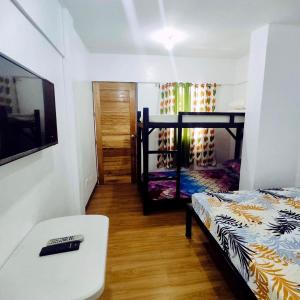 Zimmer mit einem Bett, einem Schreibtisch und einem Bett in der Unterkunft Capaclan Centro Private Room in Romblon