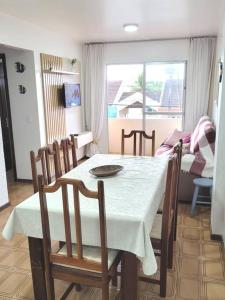 a dining room with a table and chairs and a couch at Apartamento Brejatuba Beira Mar in Guaratuba
