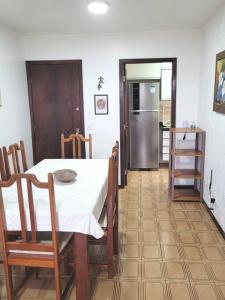 cocina y comedor con mesa y nevera en Apartamento Brejatuba Beira Mar en Guaratuba