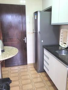 a kitchen with a refrigerator and a counter top at Apartamento Brejatuba Beira Mar in Guaratuba
