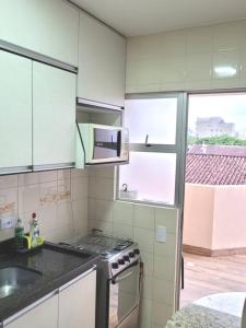 a kitchen with a stove and a microwave at Apartamento Brejatuba Beira Mar in Guaratuba