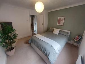 um quarto com uma cama e um vaso de plantas em Clifftop Mews - Westcliff - Ramsgate - Pet friendly! em Kent