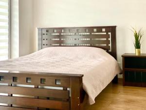 a bed in a bedroom with a wooden head board at K22 Komputerowa Warsaw Apartments in Warsaw