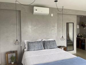 a bedroom with a white bed with two pillows at Estância Shangri-La in Santa Teresa