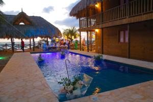 un resort con piscina con persone sedute intorno di Awa de Mar Playa a Tolú