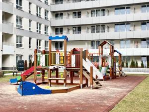 a playground in front of a large building at K22 Komputerowa Warsaw Apartments in Warsaw
