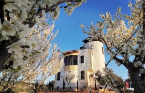 a lighthouse in the middle of trees with white flowers at Top "OverView" Resort اطلالة القمة in Al ‘Āmirīyah