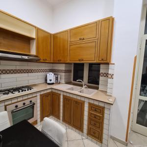 una cucina con mobili in legno e un lavello di Casa Mia al Plebiscito a Napoli