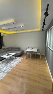 a living room with two tables and a couch at Greenside Apartment 3 in Pristina +16 photos