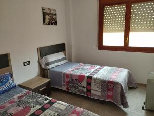 1 dormitorio con 2 camas y ventana en Apartamento Primera Línea de Mar en EbreHogar en L'Ampolla