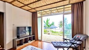 a living room with a tv and a large window at Blue Joys MSR in Siquijor