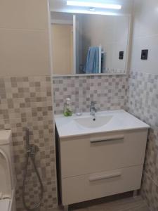 a bathroom with a sink and a mirror and a toilet at Precioso apartamento en Bilbao. in Galdakao