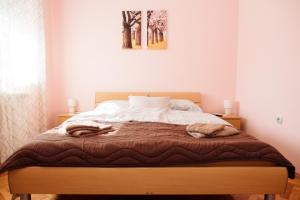 a bedroom with a bed with two towels on it at Vidak Apartman in Subotica