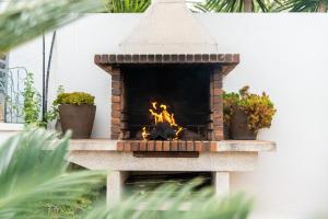 Una chimenea de ladrillo con fuego. en "Charm & Cozy 4BR - 3BA with Pool & Barbecue", en Cambrils