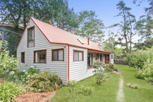 uma pequena casa branca com um telhado vermelho em Arcadia em Wentworth Falls