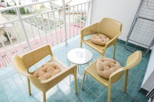 2 Stühle und ein Tisch auf einem Balkon mit Tisch und Stühlen in der Unterkunft Vidak Apartman in Subotica