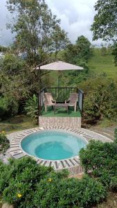 a swimming pool with a table and an umbrella at El ZORZAL in Salento