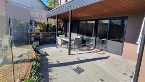 un patio al aire libre con puertas de cristal y una mesa. en Guest Suite in Duffy en Weston Creek