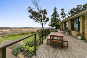 a wooden deck with a table and a view of the grand canyon at Shirri Mirri in Leura