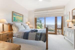 a bedroom with a bed and a large window at Shirri Mirri in Leura