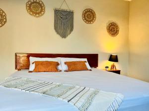 - une chambre avec un lit blanc et des oreillers orange dans l'établissement CASA VICTORIA, à Chichén Itzá