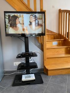 a television sitting on a stand in a living room at La Citadine in Bayeux