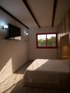 sypialnia z łóżkiem, telewizorem i oknem w obiekcie Résidence Canopée w mieście Libreville